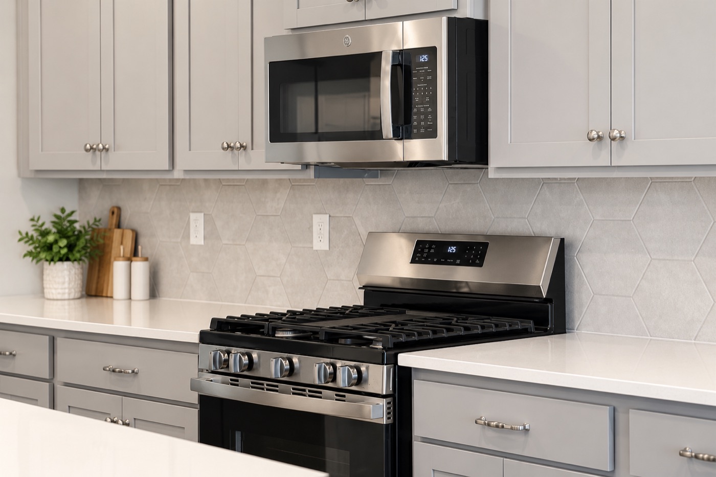Modern kitchen with stainless steel gas range, microwave, and tile backsplash
