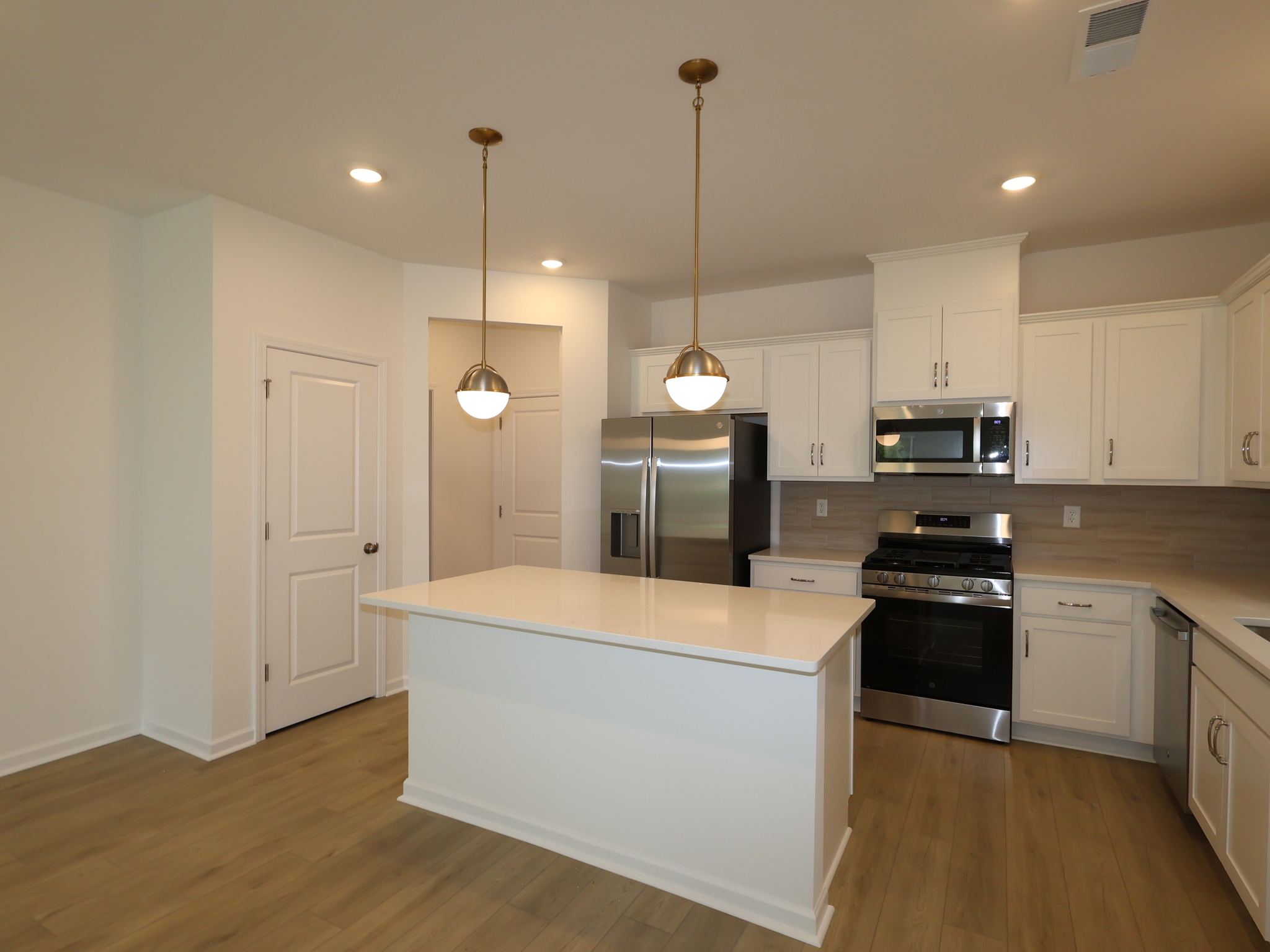 Modern kitchen with white cabinets, stainless steel appliances, and a center island